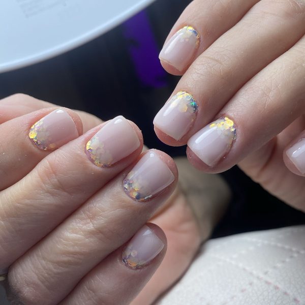 Delikatny manicure w odcieniu nude z białymi końcówkami